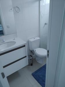y baño con aseo, lavabo y espejo. en Apto novo e bem localizado em Porto Belo - SC, en Porto Belo