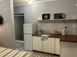 una pequeña cocina con fregadero y nevera. en Decent Stay, en Durban