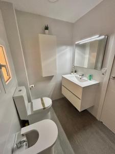 een badkamer met een wit toilet en een wastafel bij Mareny de Barraquetes in Mareny Blau