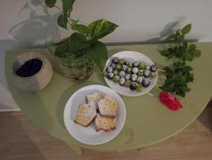 una mesa verde con dos platos de comida. en La Torre B&B Home and Relax en Amorosi