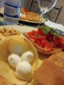 una mesa con huevos y pan y una botella de agua en La Torre B&B Home and Relax en Amorosi