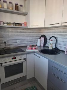 a kitchen with a sink and a stove at Apartman Nira in Zenica