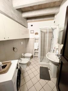 a bathroom with a toilet sink and a washing machine at Appartamenti Volta in Como +16 photos