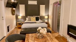 a bedroom with a bed and a couch and a tv at Phillip Island Nature Resort Villas in Cowes