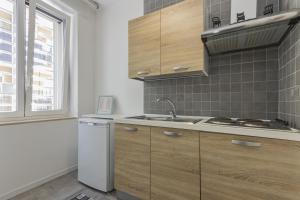 cocina con armarios de madera, fregadero y ventana en Moca Rooms, en Bari