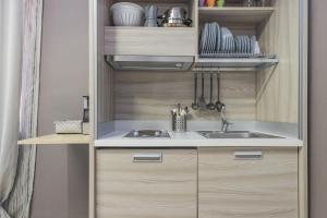 a kitchen with wooden cabinets and a sink at Moca Rooms in Bari