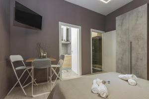 1 dormitorio con cama, mesa y TV en Moca Rooms, en Bari