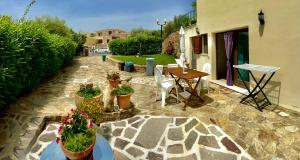 un patio con tavolo, sedie e piante in vaso di Casa Debili a San Teodoro