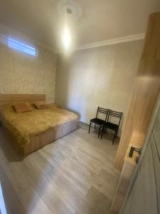 a bedroom with a bed and a table and a chair at ByurHouse in Byurakan