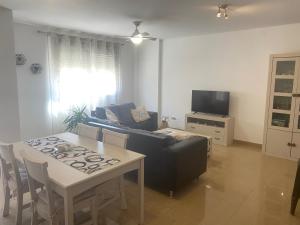 ein Wohnzimmer mit Sofa und Tisch in der Unterkunft Apartamento San Vicente in Villar del Arzobispo