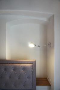 a room with a bed and a light on the wall at Old Town Flat with Private Patio in Kutná Hora