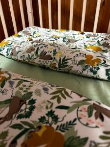 a crib with a bedsheet with flowers on it at Bed 100s in Livata