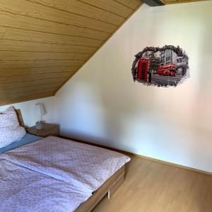 a bedroom with a bed and a train picture on the wall at Ferienwohnung Klara in Meßstetten