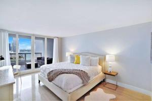 a white bedroom with a bed and a large window at Endless Summer! Incredible Water Views in Miami +29 photos