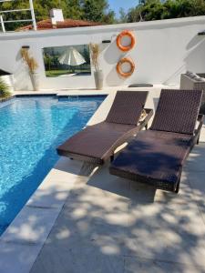 two chairs sitting next to a swimming pool at La Pinta Hotel Boutique in San Bernardino