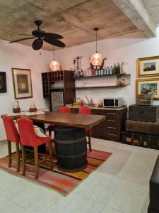 uma cozinha com uma mesa de madeira e cadeiras vermelhas em La Pinta Hotel Boutique em San Bernardino