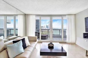 ein Wohnzimmer mit einem Sofa und einem großen Fenster in der Unterkunft Endless Summer! Incredible Water Views in Miami