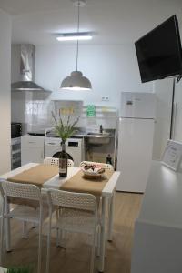 a kitchen with a table and chairs and a television at Serendipia in Avila