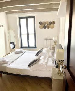 コモにあるAppartamenti Voltaのベッドルーム1室(白いシーツ付きのベッド1台、窓付)