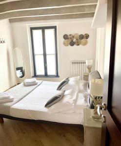 a bedroom with a bed with white sheets and a window at Appartamenti Volta in Como