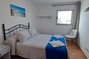 a small bedroom with a bed and a window at Casa Abuelo Antonio in El Cotillo