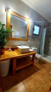 a bathroom with a sink and a toilet and a mirror at Casa Abuelo Antonio in El Cotillo