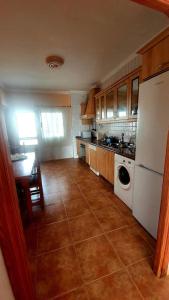 a kitchen with a white refrigerator and a table at Casa Abuelo Antonio in El Cotillo +30 photos