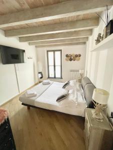 コモにあるAppartamenti Voltaのテレビ付きの客室で、白い大型ベッド1台が備わります。