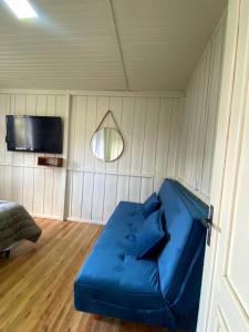 a blue couch in a room with a tv at Casa de temporada - Recanto da invernada in Urubici