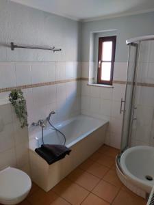 ein Badezimmer mit einer Badewanne, einem WC und einem Waschbecken in der Unterkunft Ferienwohnung Obere Aue in Niederau