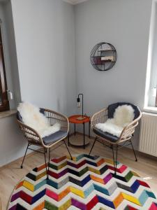 ein Wohnzimmer mit 2 Stühlen und einem bunten Teppich in der Unterkunft Ferienwohnung Obere Aue in Niederau