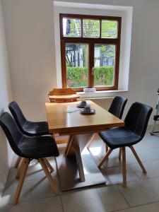einen Esstisch mit zwei schwarzen Stühlen und einem Fenster in der Unterkunft Ferienwohnung Obere Aue in Niederau