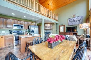 uma cozinha e sala de jantar com uma mesa de madeira com flores em Lake-View Home in Blue Eye with Hot Tub and Fire Pit! em Blue Eye