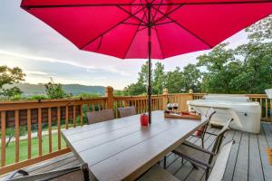 a wooden table with a red umbrella on a deck at Hot Tub and Fire Pit! Lake-View Home in Blue Eye in Blue Eye