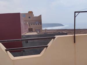 - une vue sur un bâtiment avec l'océan en arrière-plan dans l'établissement Belles appartements à côté de la plage Tamehrouchte, à Mirleft