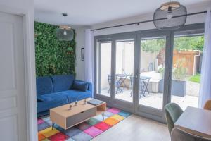 a living room with a blue couch and a table at Le Saint-Germain - Porte d'Orléans - Cité Universitaire Paris 14 in Gentilly