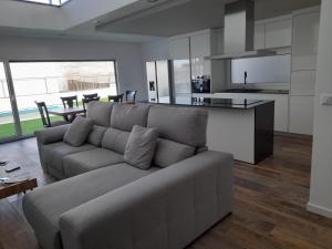 uma sala de estar com um sofá e uma cozinha em Casa Roma em Sesimbra