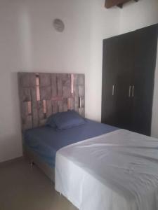 a bedroom with a bed with a wooden headboard at CASA AMOBLADA EN CONJUNTO CERRADO in Cúcuta