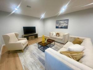 a living room with two white couches and a television at Spacious & Modern 4B3B house in Pasadena in Pasadena