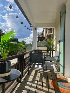 a balcony with chairs and tables on a house at T3-Balcon plein sud-Accès direct au bord du Loing in Moret-sur-Loing
