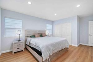 a white bedroom with a large bed and a window at Spacious & Modern 4B3B house in Pasadena in Pasadena