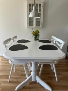 mesa de comedor blanca con 4 sillas y pared blanca en Bolding Apartments, en Billund