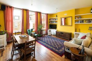 a living room with a couch and a table at Elegant and Peaceful 2BD apt - Barons Court/London in London
