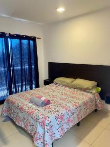 una camera da letto con un letto con copriletto a fiori di Mandua a Puerto Iguazú