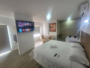 - une chambre avec un lit et une télévision murale dans l'établissement Terramar Hoteles, à Crucita