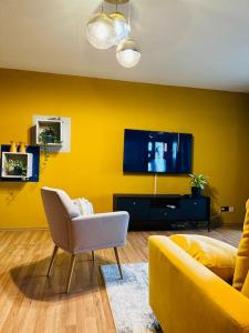 a yellow living room with a couch and a tv at Centro-ist-nicht-mehr-weit in Oberhausen
