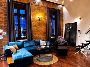 a living room with a blue couch and a brick wall at Loft Sava View Old Town Renovated in Belgrade