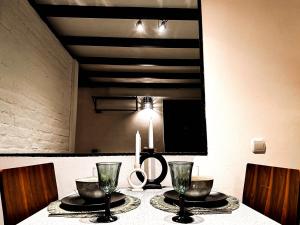 a dining room table with two candles and a mirror at Loft Sava View Old Town Renovated in Belgrade