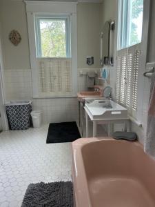 a bathroom with a pink tub and a sink at Enloe House in Roanoke