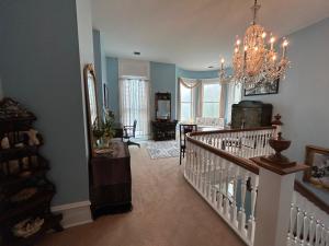 a living room with a staircase and a chandelier at Enloe House in Roanoke